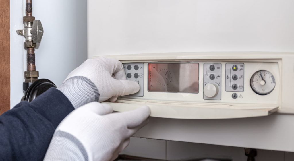 Technician servicing heating boiler in a house. Maintenance concept